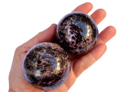 Two rhodonite spheres 60mm-65mm on hand with white background