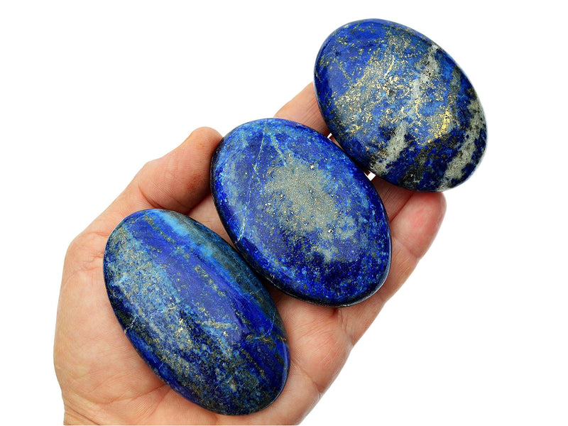 Three lapis lazuli palm stones 80mm on hand with white background
