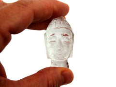 One mini clear quartz buddha head figure 45mm on hand with white background
