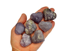 Seven lepidolite crystal hearts 35mm-40mm on hand with white background