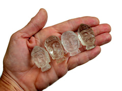 Four mini clear quartz buddha head figures 35mm-40mm on hand with white background