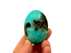 One green amazonite palm stone 50mm on hand with white background