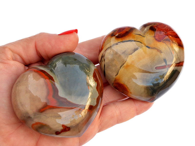 Two large desert jasper crystal heart 70mm on hand with white background