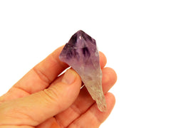 One raw purple amethyst crystal point 40mm on hand with white background