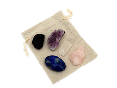 Raw black tourmaline, druzy amethyst, raw rose quartz, clear quartz point and lapis lazuli palm stone on small jute bag
