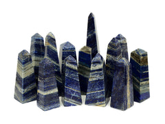 Some natural lapis lazuli obelisks in different sizes on white background