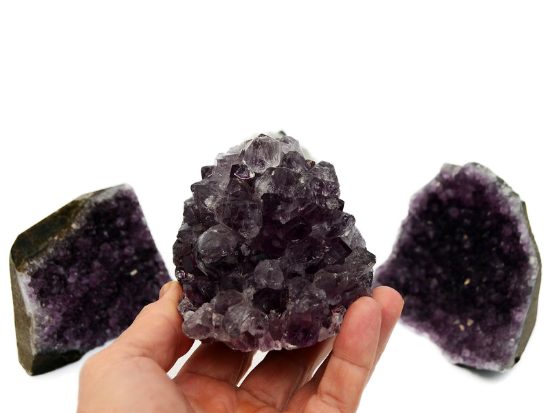 One druzy amethyst cut base 65mm on hand with background with two amethysts on white