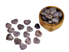 Several small lepidolite heart minerals inside a wood bowl and outside on white background 