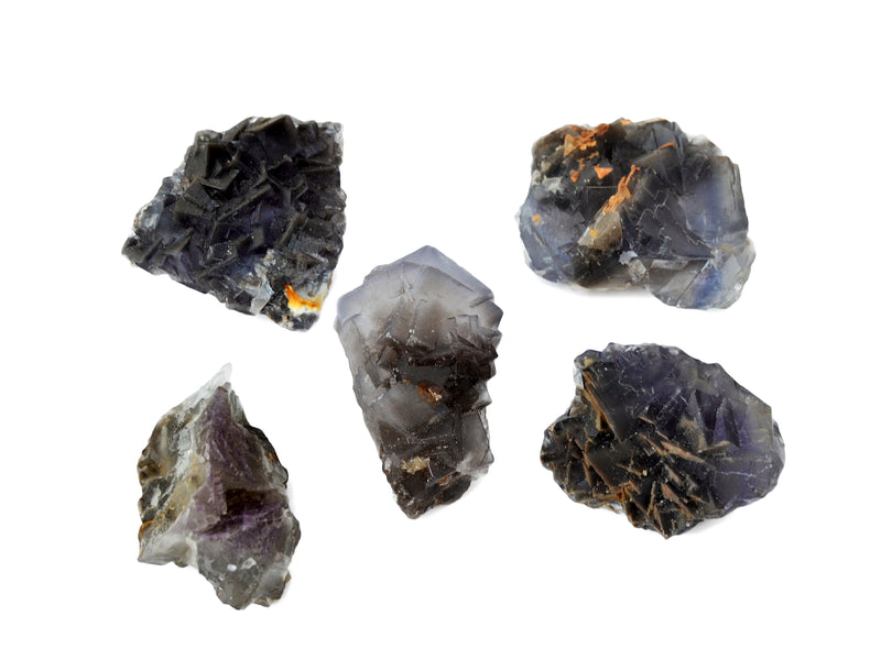 Five purple fluorite cluster crystals on white background