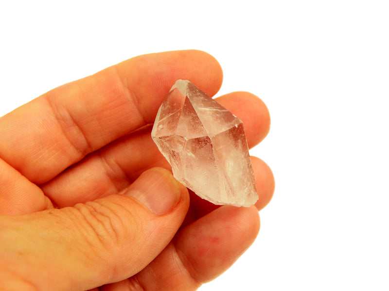 One raw clear quartz point 30mm on hand with white background