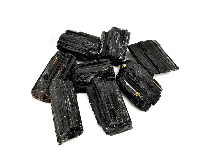 Eight rough black tourmaline crystals 25mm-60mm on white background