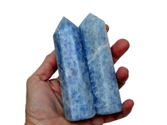 Two blue calcite tower stones 110mm on hand with white background