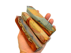 Three desert jasper faceted points on hand with white background