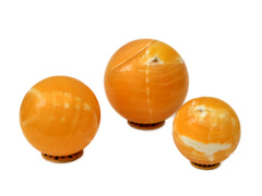 Three large orange calcite sphere crystals 85mm-100mm on white background