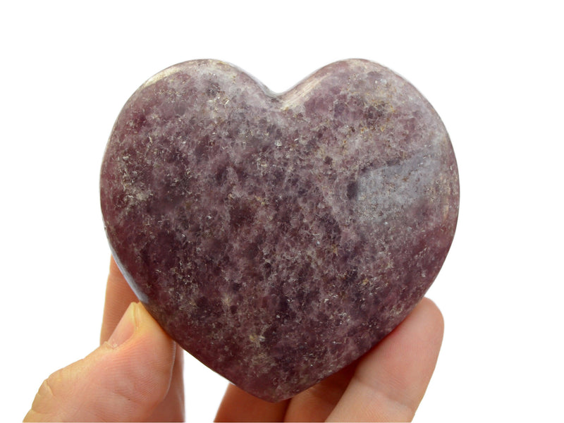 One large purple lepidolite crystal heart 75mm on hand with white background