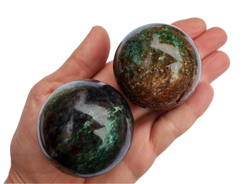 Two chrysocolla crystal spheres 50mm-55mm on hand with white background