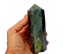 One large labradorite obelisk 110mm on hand with white background