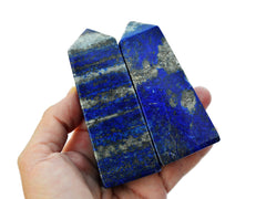 Two blue lapis lazuli crystal towers 100mm on hand with background