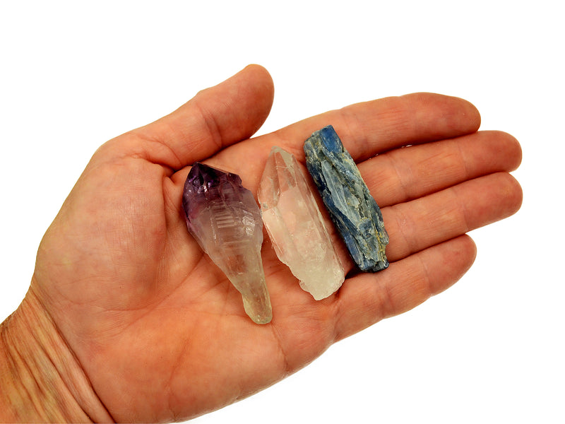 One raw amethyst point, raw clear quartz point and raw blue kyanite 50mm on hand with white background