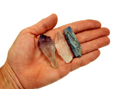 One raw amethyst point, raw clear quartz point and raw blue kyanite 50mm on hand with white background