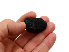 Small raw black tourmaline 30mm on hand with white background