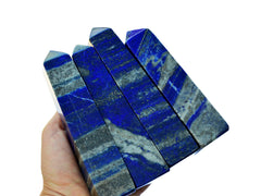 Four blue lapis lazuli crystal towers  100mm-140mm on hand with white background