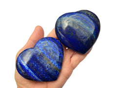 Two lapis lazuli heart shaped crystals 70mm-75mm on hand with white background