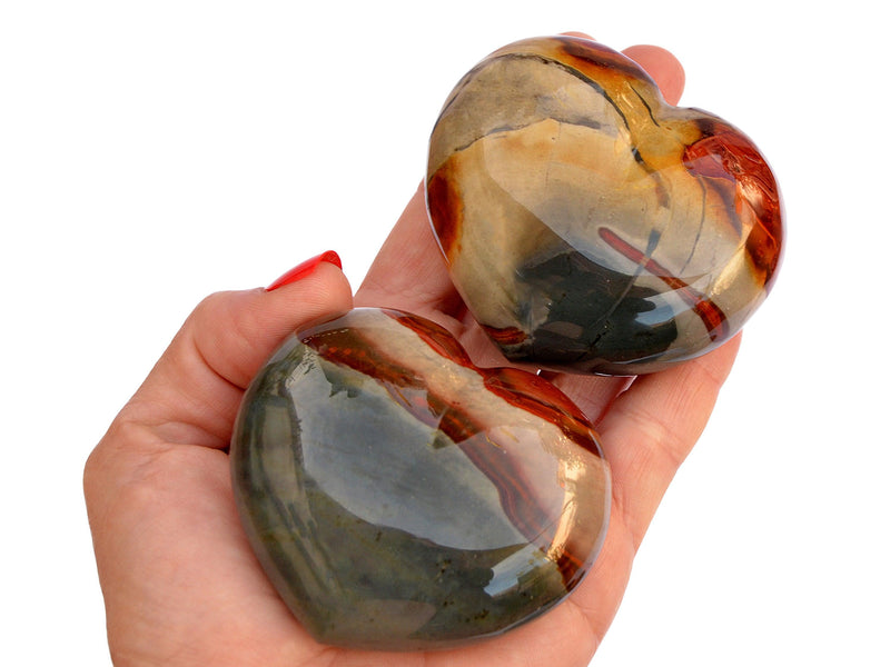 Two large desert jasper hearts 70mm on hand with white background