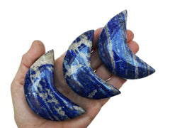 Three lapis lazuli moon crystals 70mm on hand with white background