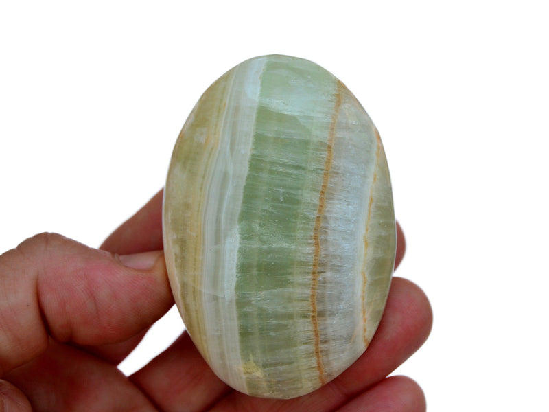 One green banded pistachio calcite palm stone 70mm on hand with white background