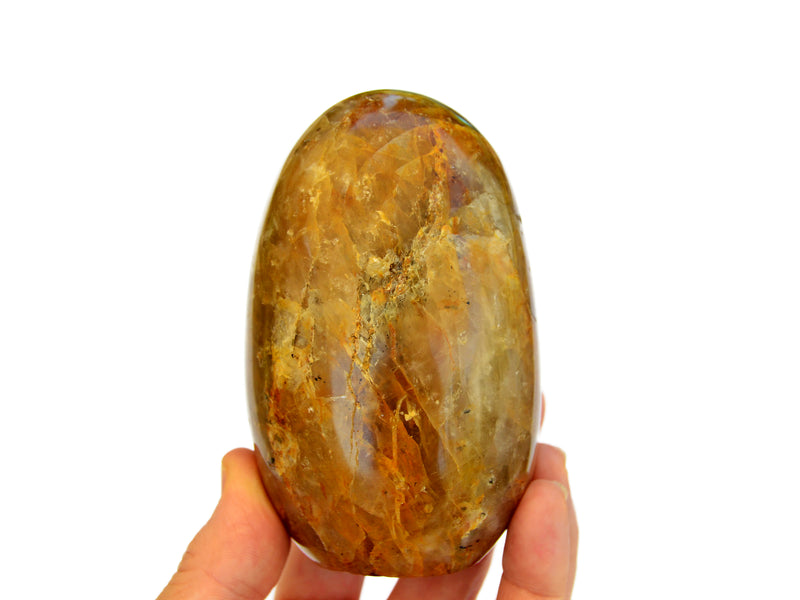 One large golden healer quartz on hand with white background