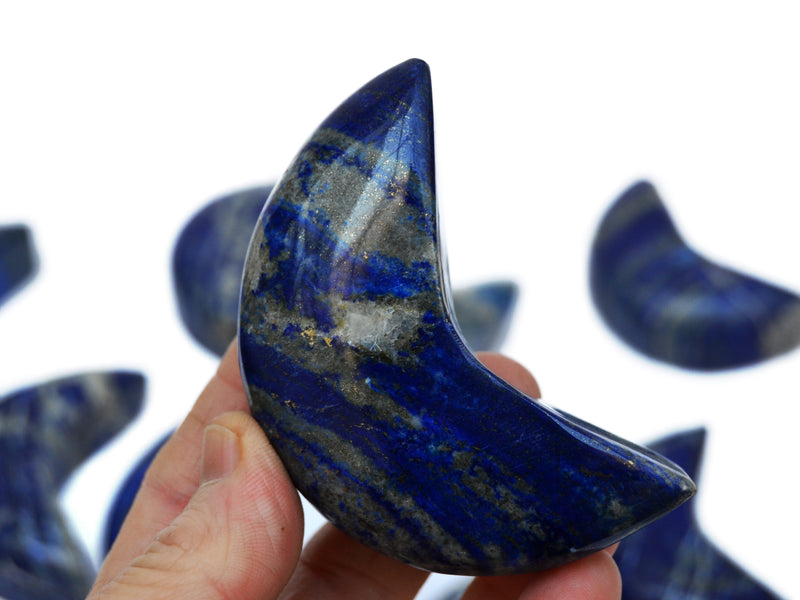 One lapis lazuli moon shaped stone 70mm on hand with white background