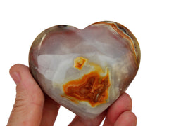 One extra large pink banded onyx heart 90mm on hand with white background