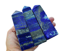 Three blue lapis lazuli large crystal towers hand with white background