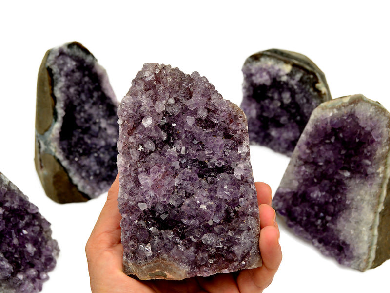 Natural druzy amethyst cut base 110mm on hand with background with some crystals on white