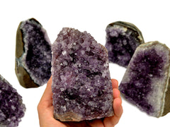 Natural druzy amethyst cut base 110mm on hand with background with some crystals on white