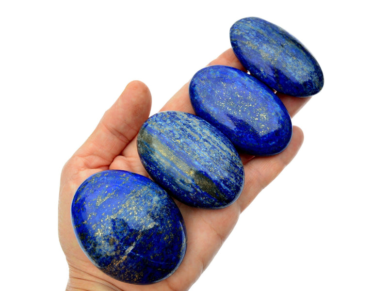 Four lapis lazuli palm stones 45mm-80mm on hand with white background