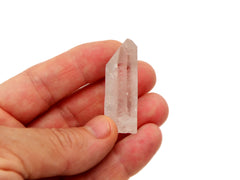 Clear quartz raw crystal point 30mm on hand with white background