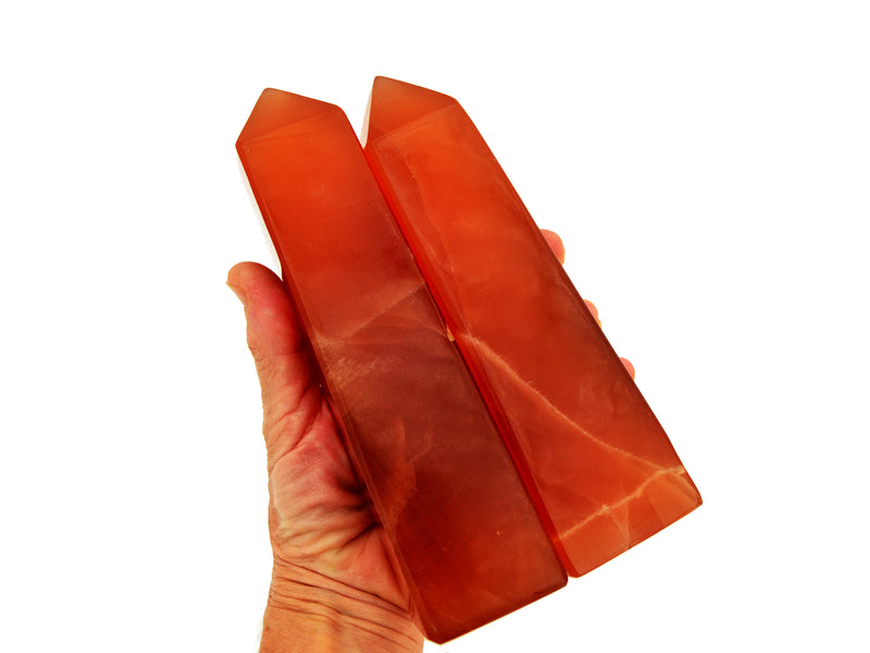 Two large honey calcite obelisks 170mm-180mm on hand with white background