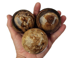 Three chocolate calcite sphere crystals 65mm-70mm on hand with white background
