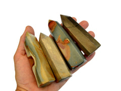 Four polychrome jasper towers on hand with white background