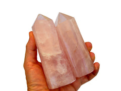 Two large pink quartz towers 120mm on hand with white background