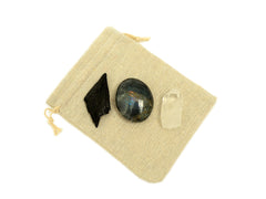 Raw black kyanite, labradorite palm stone and raw clear quartz point on small jute bag