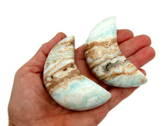 Two caribbean calcite moon shapped crystals 75mm on hand with white background