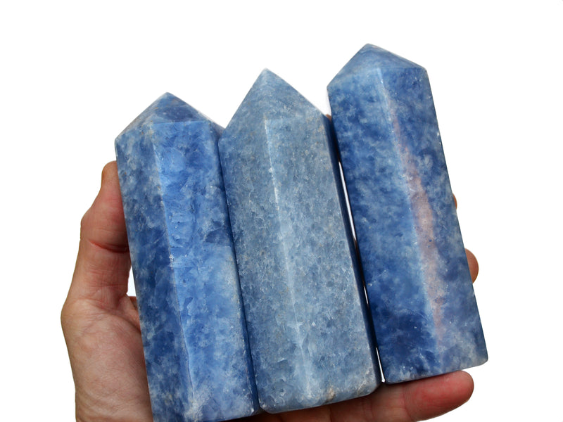 Three large blue calcite points 120mm on hand with white background