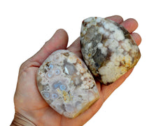 Two sakura flower agate free forms on hand with white background