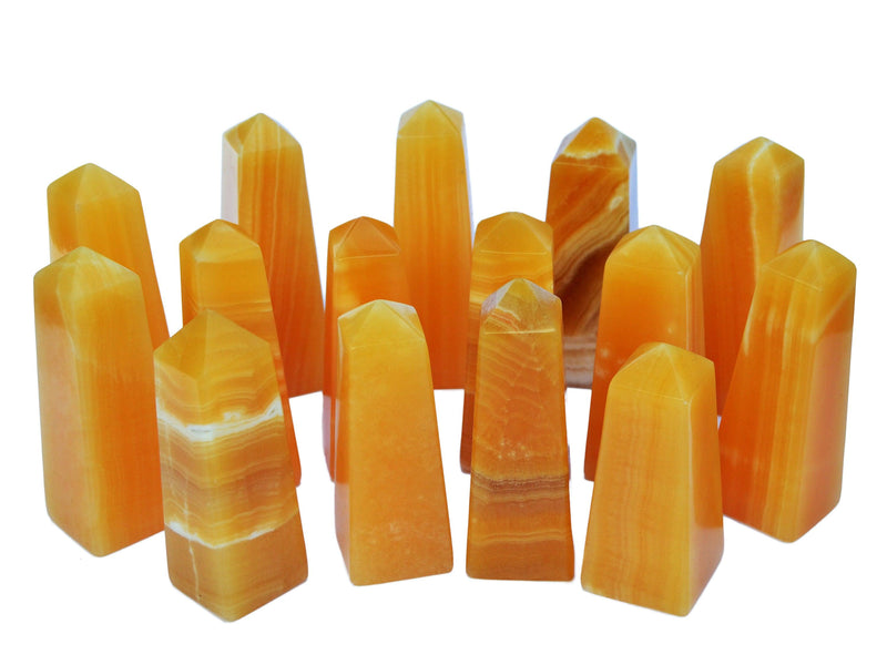 Several orange calcite towers 50mm-115mm on white background