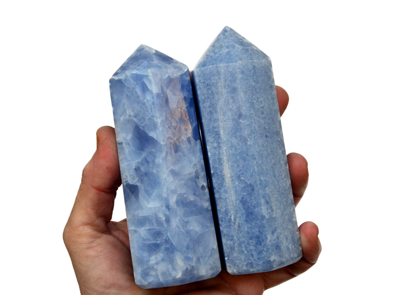 Two chunky blue calcite faceted points 120mm on hand with white background