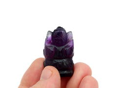 Reverse of mini amethyst ganesha sculpture 35mm on hand with white background