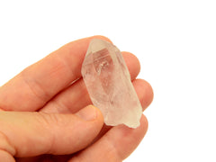One raw clear quartz point 30mm on hand with white background